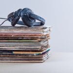 Stack of many black vinyl recordss, headphones put on the top of vinyls. Copy space for text. Candid people, real moments, authentic situations