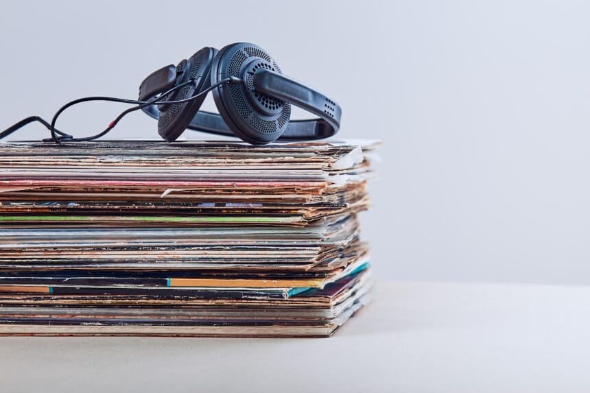 Stack of many black vinyl recordss, headphones put on the top of vinyls. Copy space for text. Candid people, real moments, authentic situations