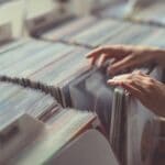 Women's hands browsing records in a vinyl record store