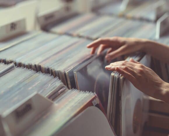 Women's hands browsing records in a vinyl record store