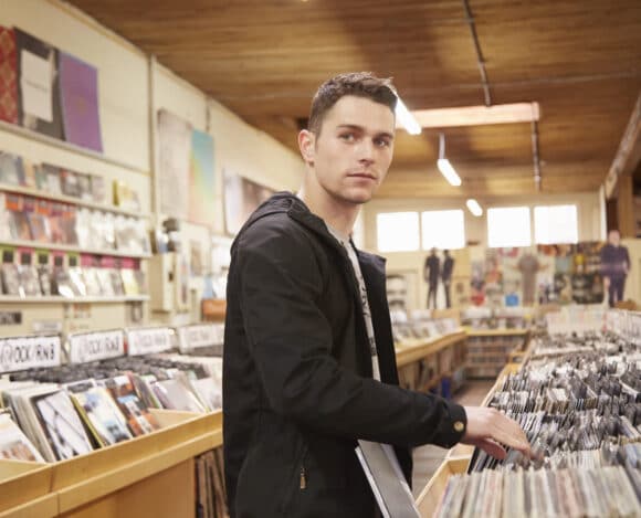 Young man browsing vinyl records in music store