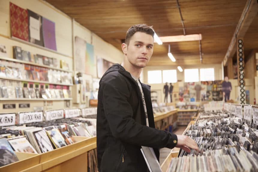 Young man browsing vinyl records in music store